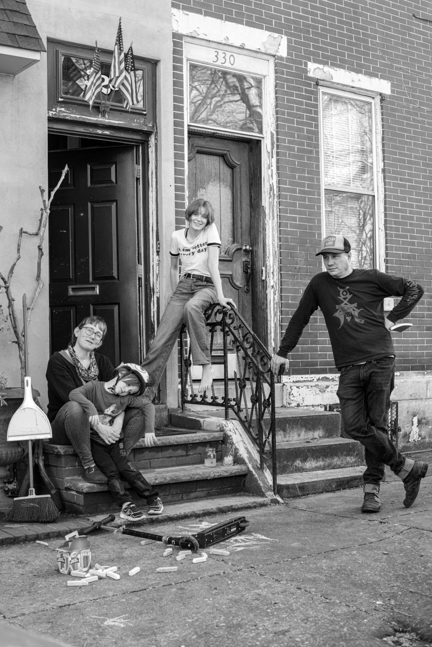 Four family members pose outside their front door