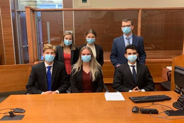 Six students pose for a picture in the courtroom