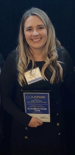 Paige Love holding an award plaque