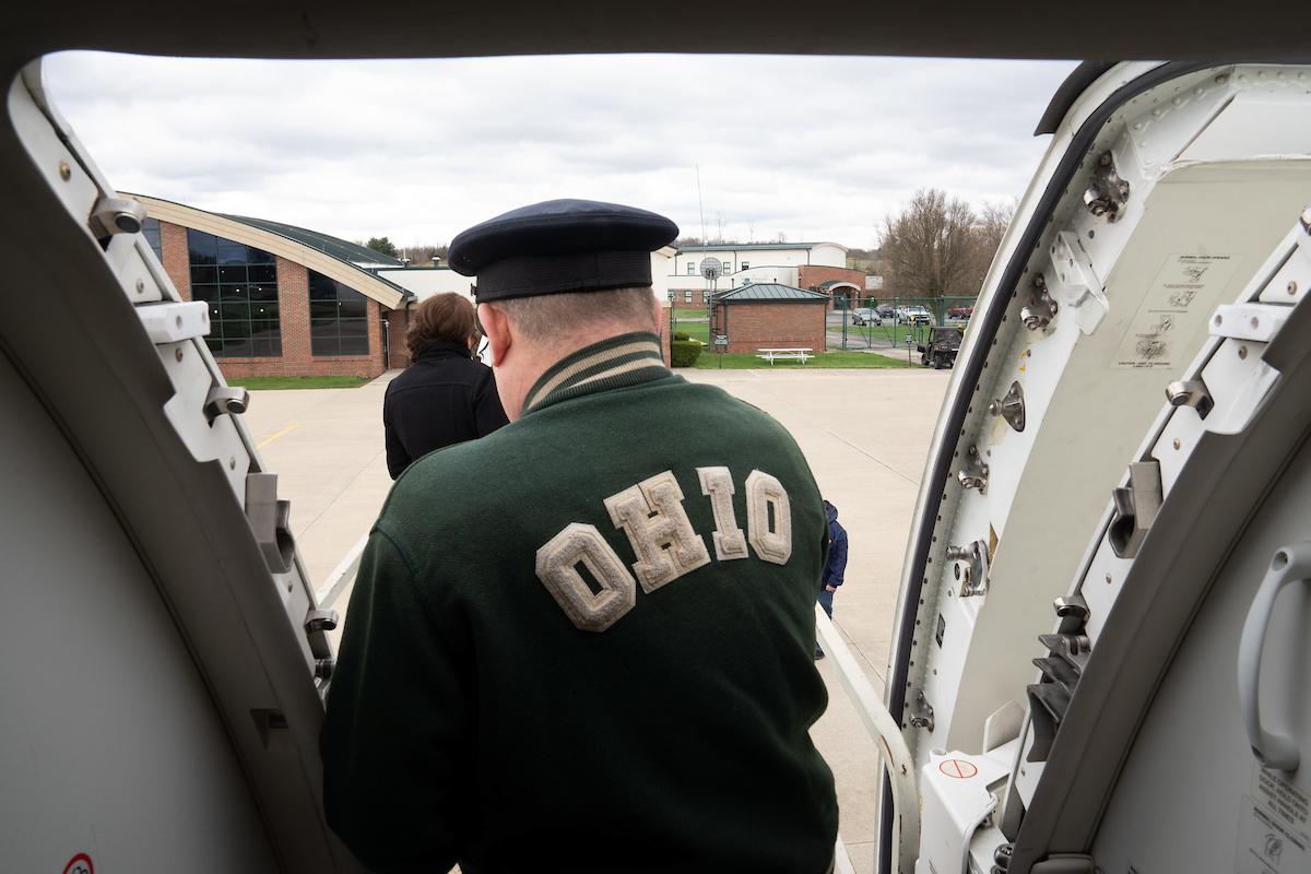 Dan Sneddon is shown wearing his OHIO coat while he is walking off of a Republic Airways jet