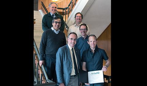 Dr. Andreas Weichselbaum holds his notable alumni award with faculty from the College of Arts & Sciences