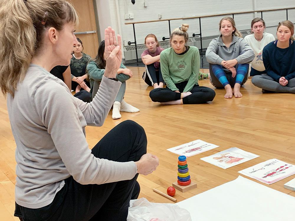 Christi Camper Moore sits with class of students