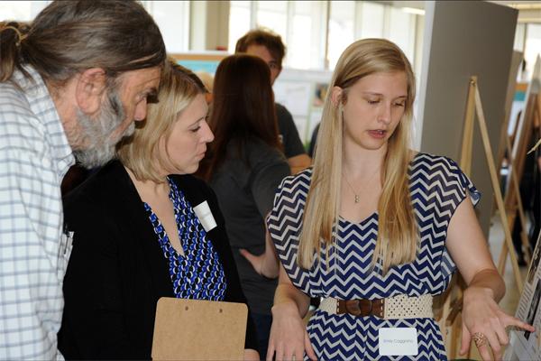 Scott Moody serving as a judge at the OHIO Student Research Expo in 2016, listening as then-undergrad Emily Caggiano explains her poster on albatross functional anatomy.