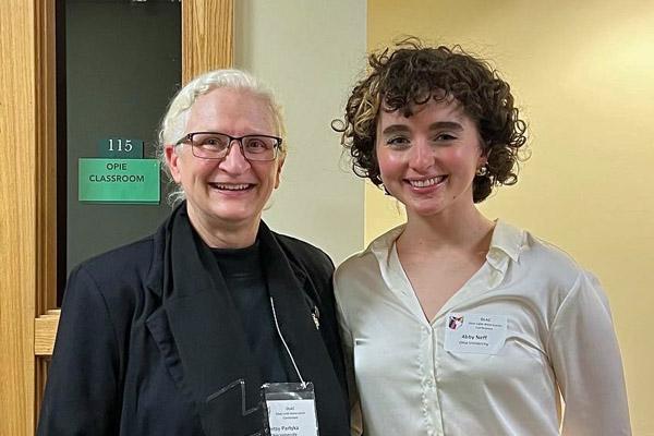 Dr. Betsy Partyka and Abby Neff take a moment to relax during the annual pizza party and creative readings portion of the conference.