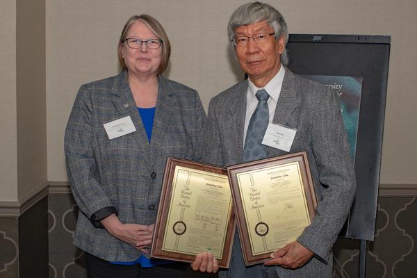 Jianchao Zhu holds two patent plaques