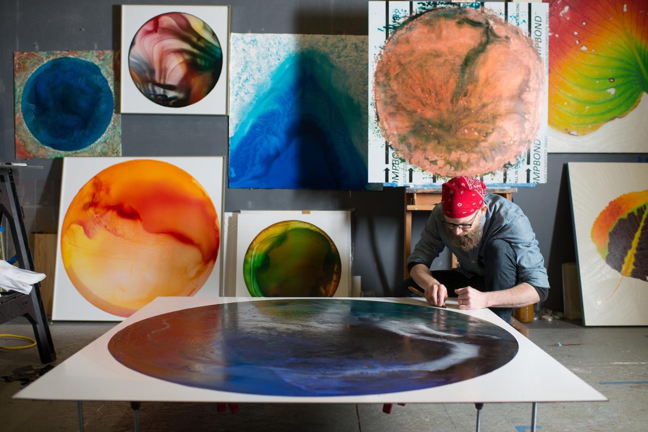 John Sabraw is shown working  with artwork in his studio