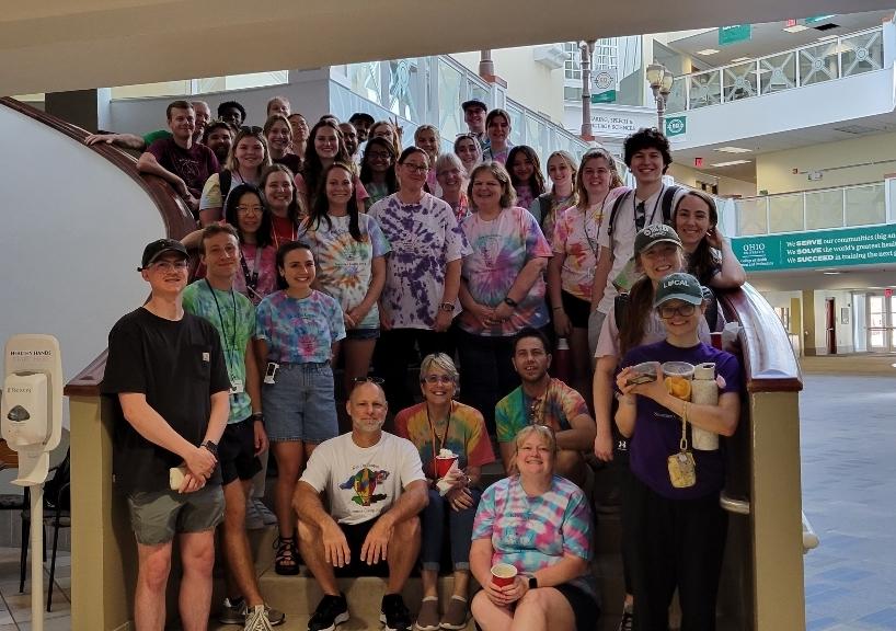 Staff members pose for a group picture on a stairwell 