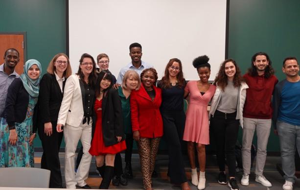 The M.A. class of ’23, from left: Gorrie B Jallow, Nour Maache, Sam Metzger, Claire Molitors, Lynden Caldwell,  Qinwen Pan, Miki Suzuki, Simon Egleh, Sara Abdelrahman, Josssy Mutisya, Afua Kwarteng, Merve Ocak, Oussema Dhieb, and Ayman Elbarbary.