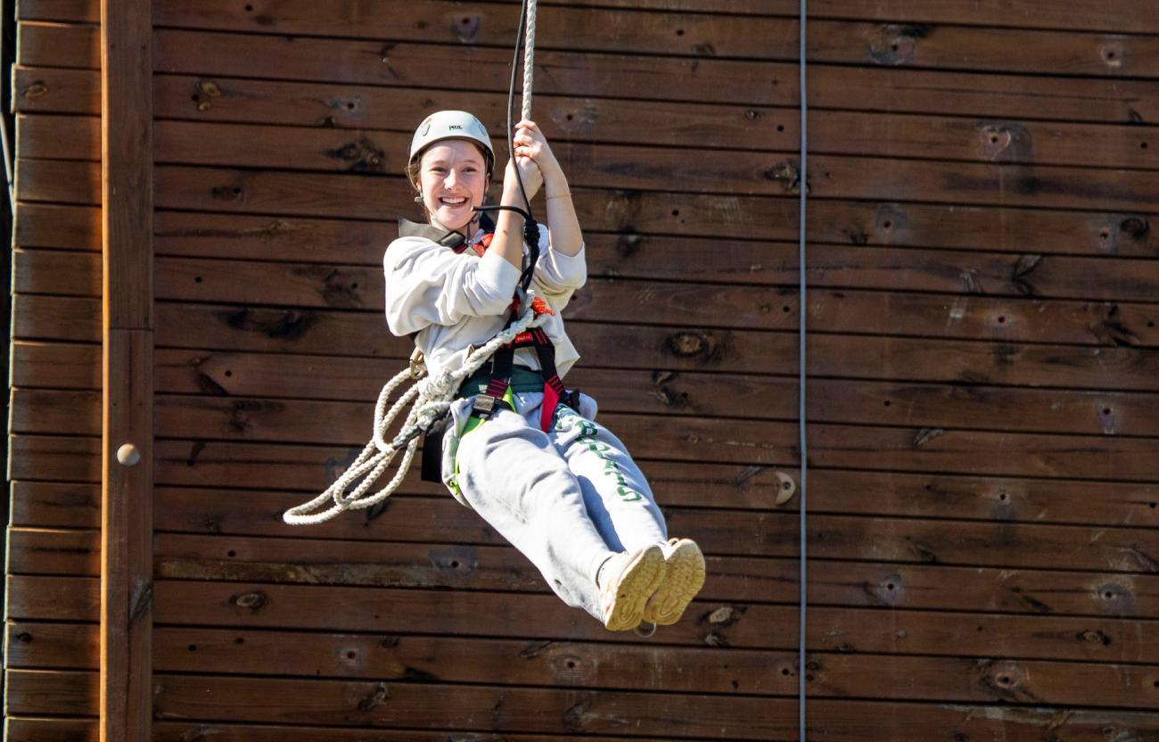 An OHIO student is shown on a zip line at The Ridges