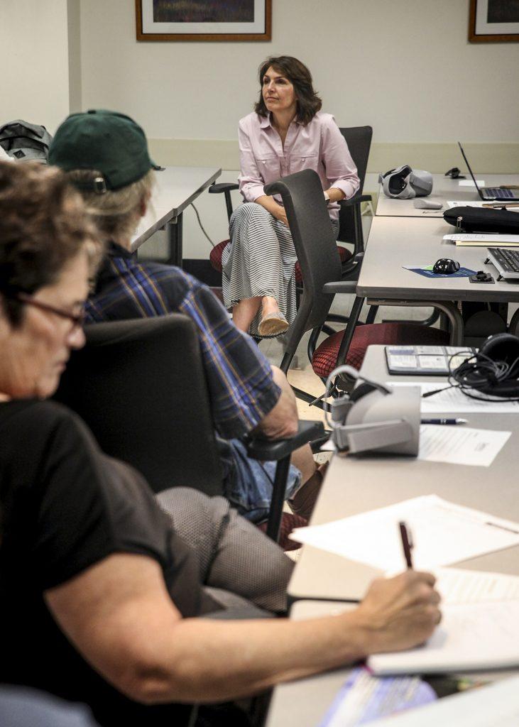 Ruth Dudding [TOP], director of Community Health and Engagement for the Athens City-County Health Department, takes in feedback from community health workers who received virtual reality training on Narcan use.