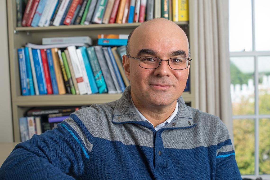 Roberto Duncan sits in his office in front of a bookshelf.