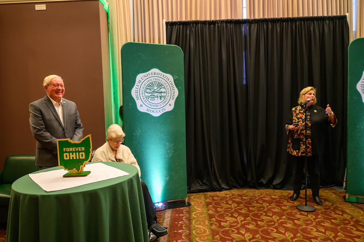 President Lori Stewart Gonzalez is shown speaking with M. Duane Nellis and Ruthie Nellis listen during the retirement ceremony