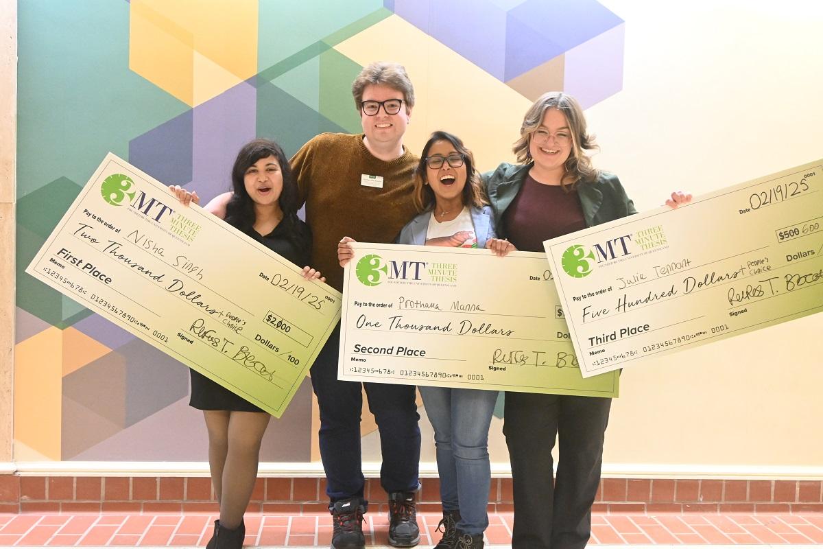 Participants in the 3MT Competition pose with giant checks showing their prizes