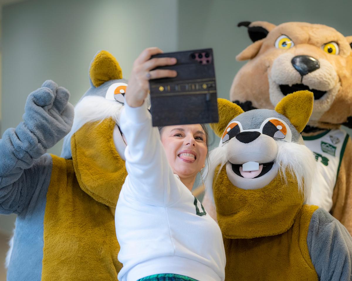 An OHIO supporter poses for a photo with Rufus and some squirrel mascots