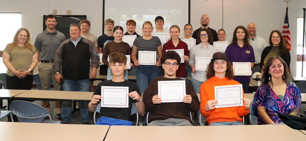 Students and teachers involved in the ASER Student Summary Project Student Expo pose for a group photo, while some students hold their certificates