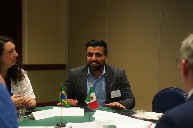 Hashim Pashtun speaks while sitting at a table at the event