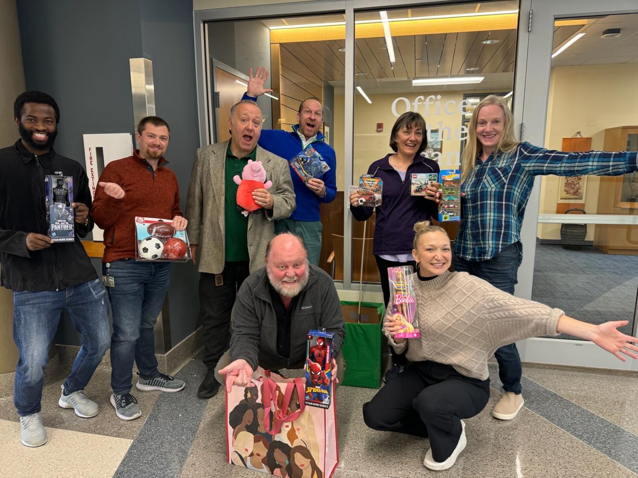 David Morkeh hold toys and action figures as pose for a group photo at Ohio University Lancaster