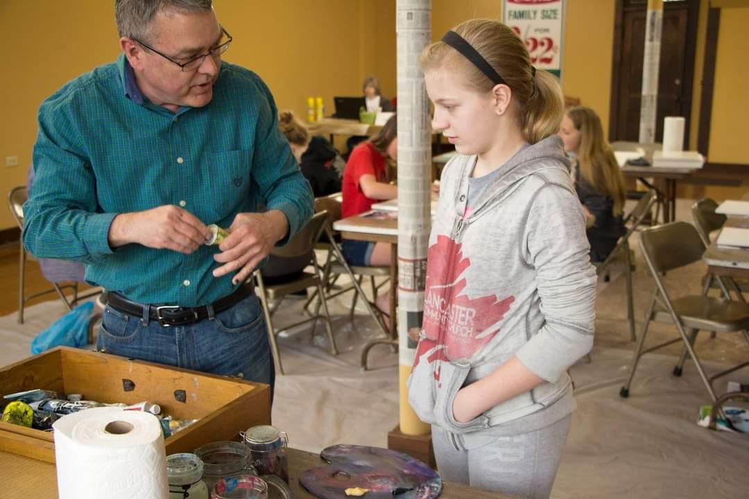 Wren Denny and Troy Sayers work together on an art project in a photo from several years ago