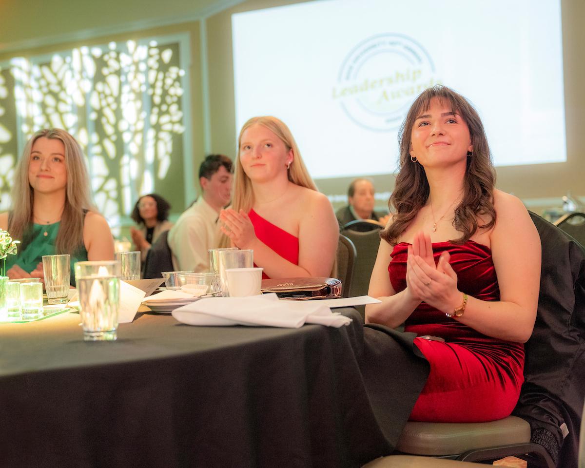 Audience members applaud while sitting at a table at the 2025 Leadership Awards