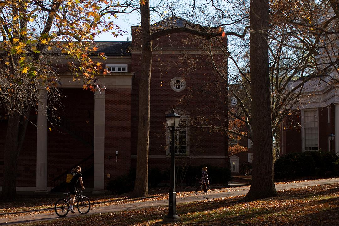 A student bikes on College Green.