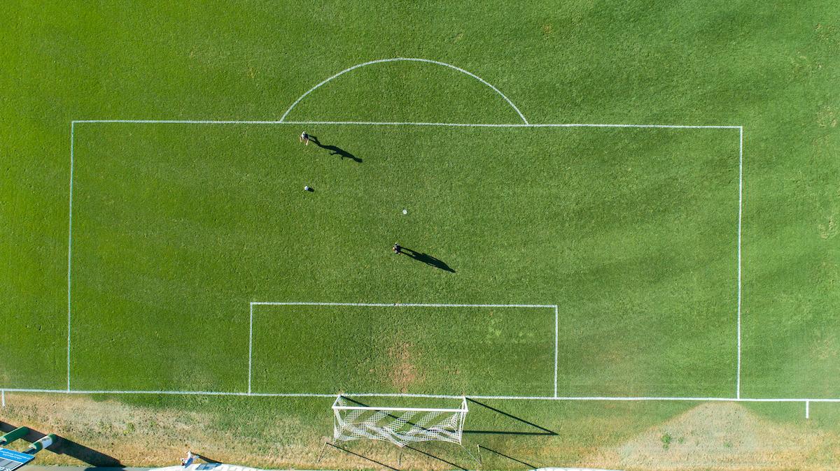 Soccer players are shown on the field in this aerial image from above the pitch