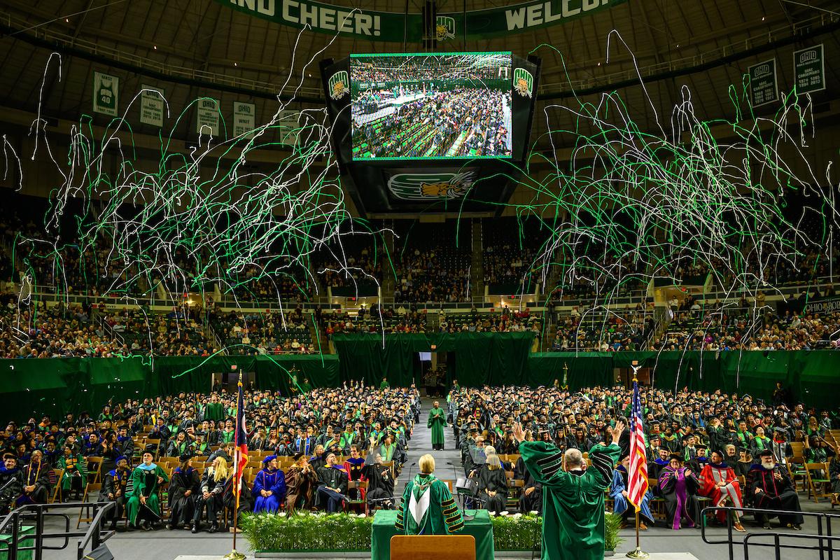 Green and white streamers explode over the 2025 fall Commencement ceremony