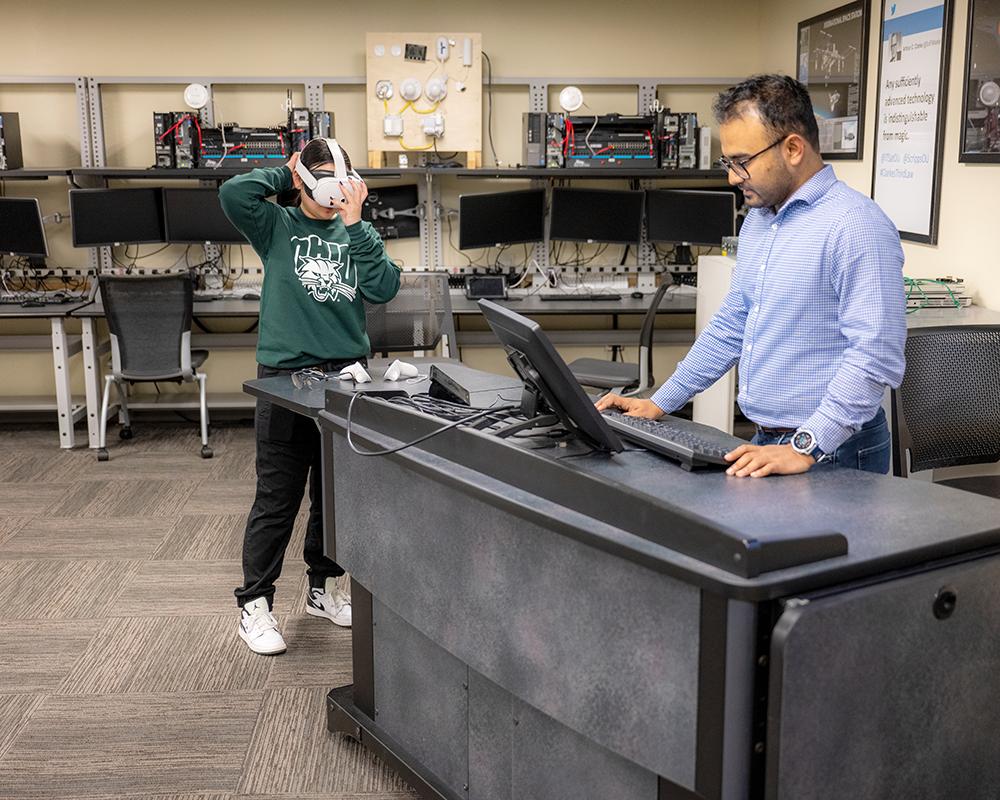 Assistant Professor Rishabh Das programs a cyber-physical environment for a student to explore.