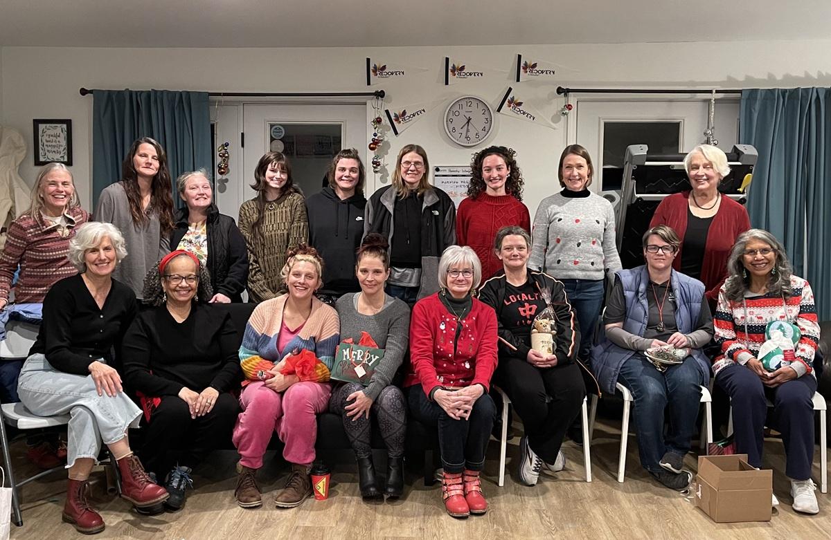 Staff and clients at Serenity Grove stand and sit together for a group photo.
