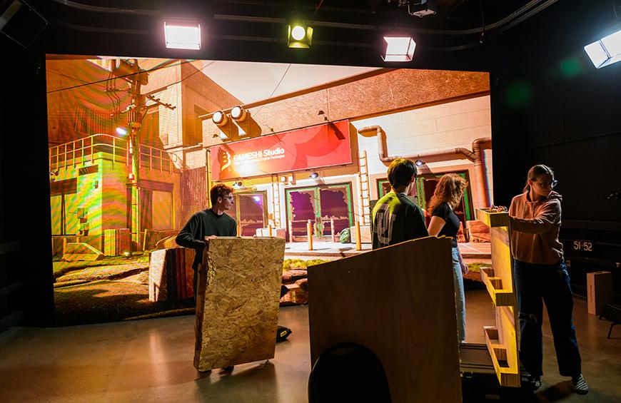 LED Wall Production students move props in front of the wall.