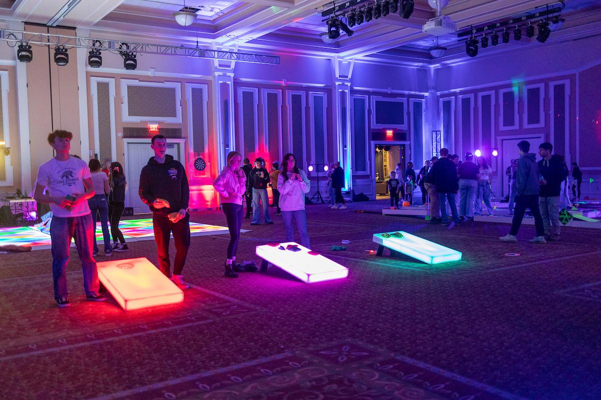 OHIO students and their siblings play a lit up cornhole game during GLOHIO in the Baker University Center as part of Sibs Weekend 2025.
