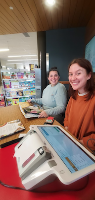People smiling at camera at checkout services