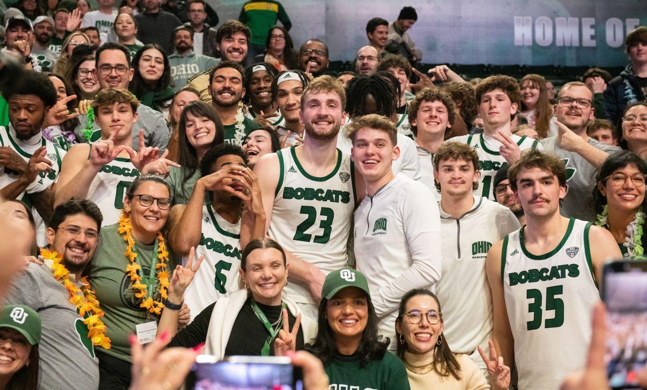 Members of the LAIOB program stand with members of the OHIO Men's Basketball Team after a basketball game in the Convocation Center