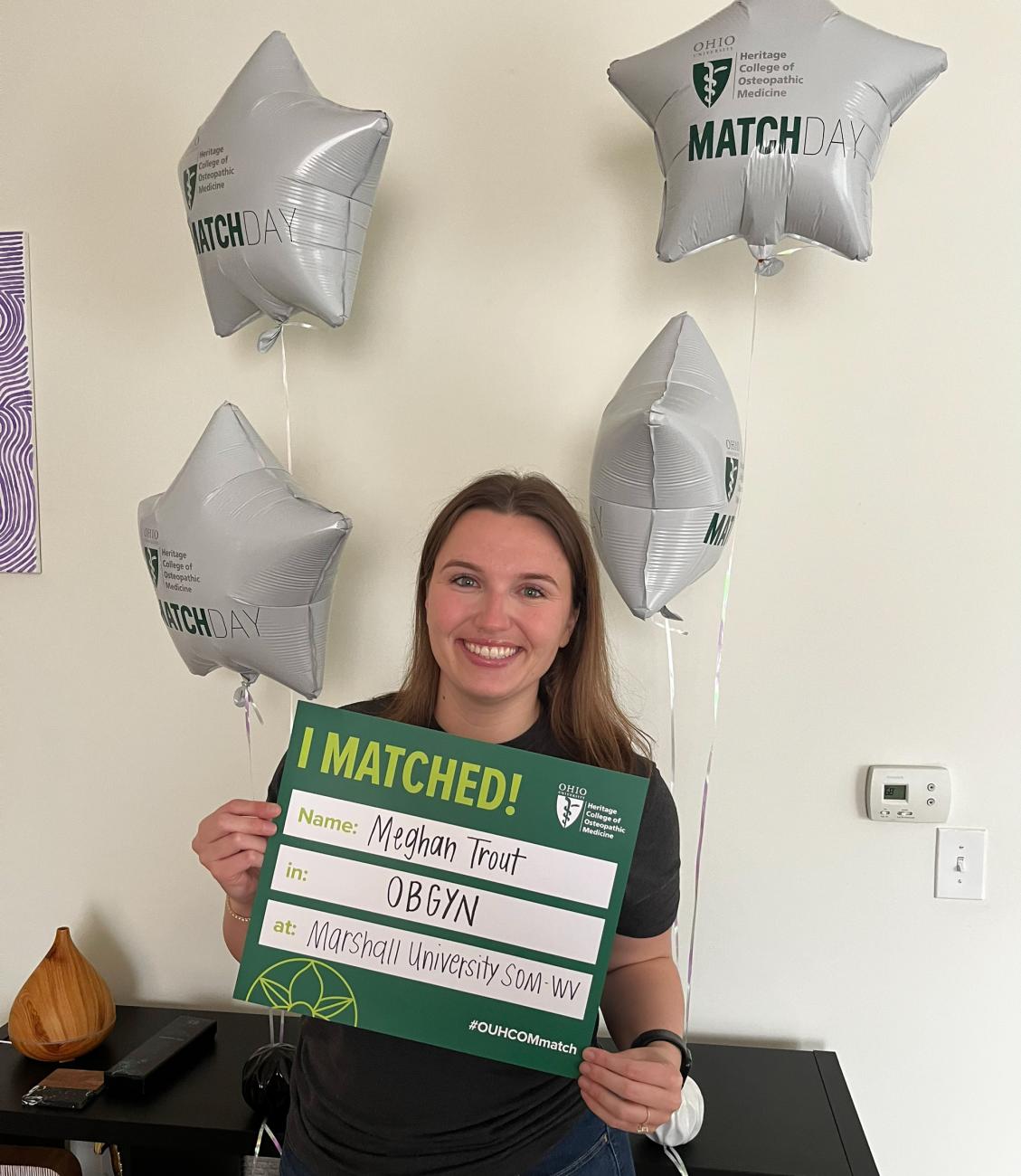 HCOM student Meghan Trout holds Match Day sign