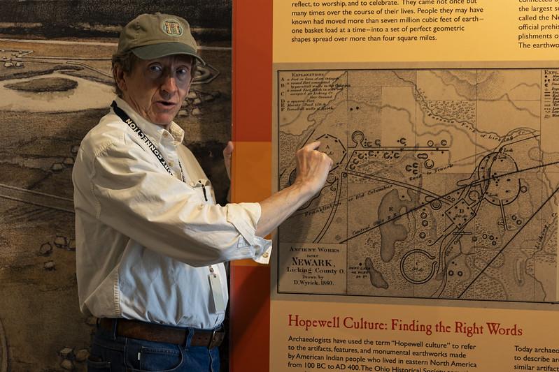 An individual points to a map showing the Hopewell Earthworks while giving a presentation