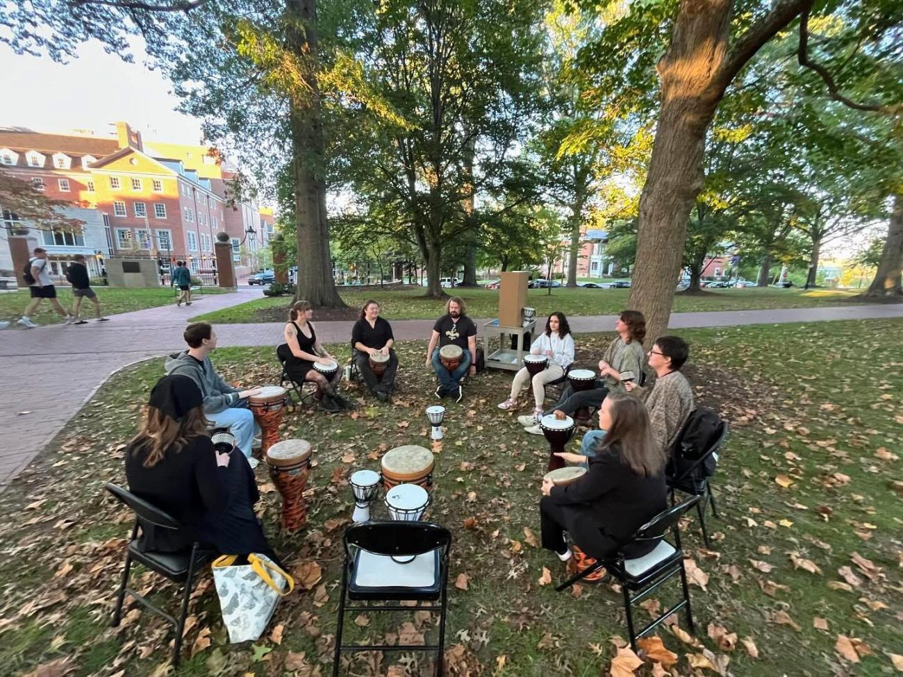 OHIO students play drums in a drum circle while on the College Green