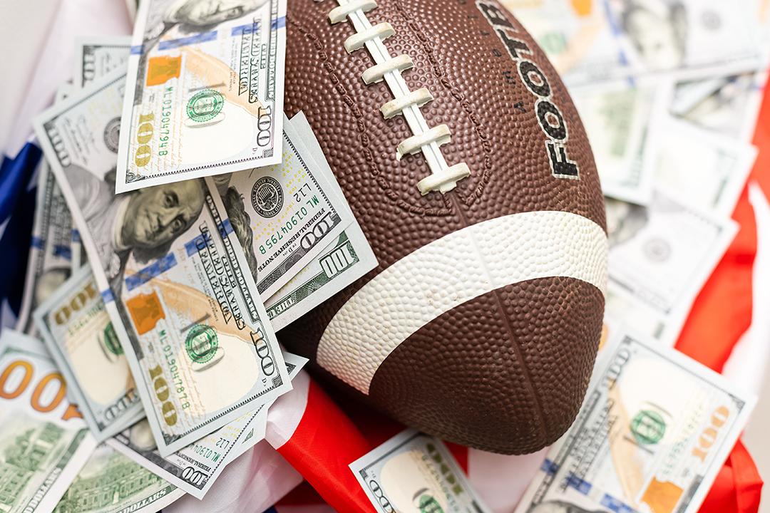 A football with $100 bills surrounding it.