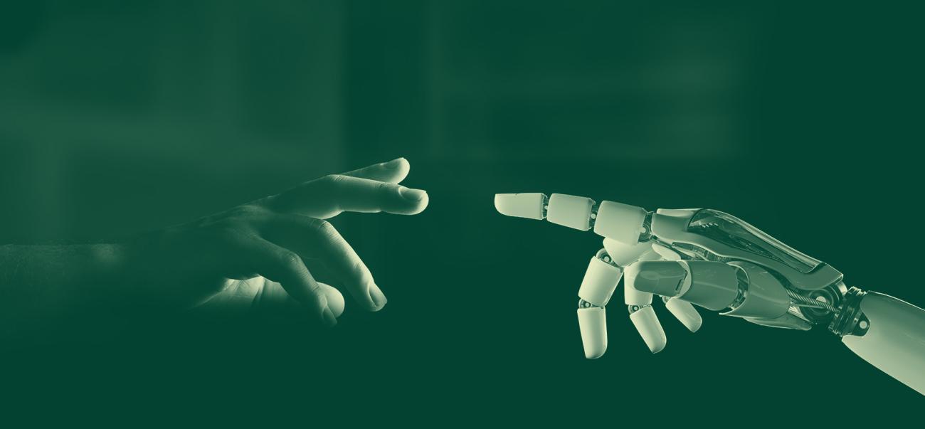 A human hand and a robotic hand meet, touching fingers.