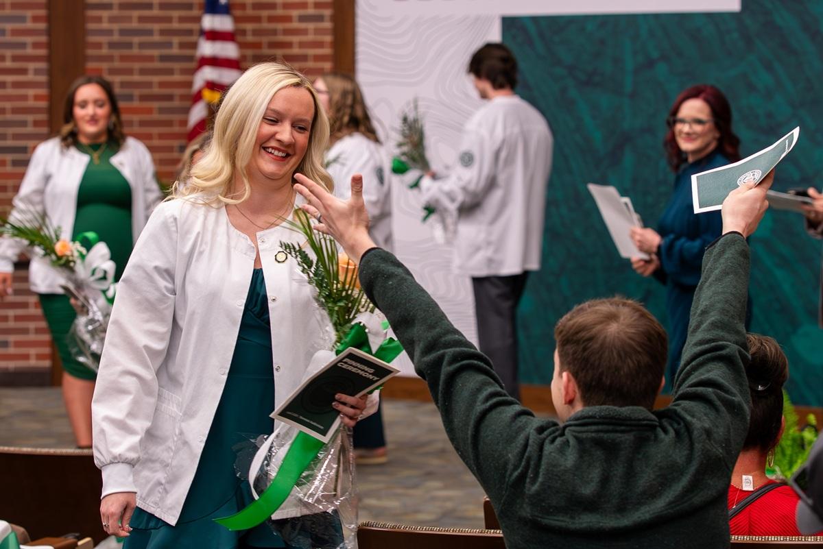 An OHIO student walks up to greet a family member or friend after the pinning ceremony 