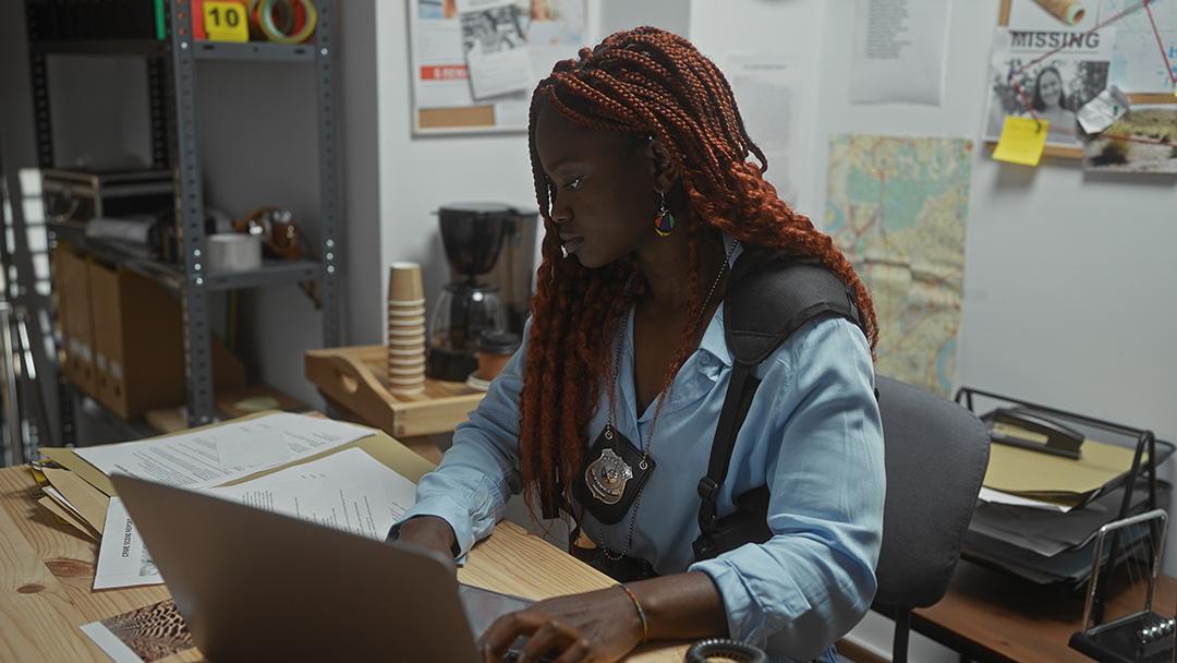 A stock image of a law enforcement officer working on an investigation.