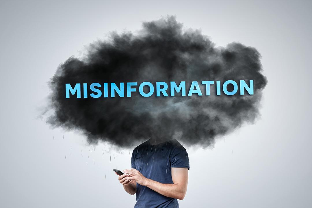 A person uses a phone with a cloud labeled "misinformation," above their head.