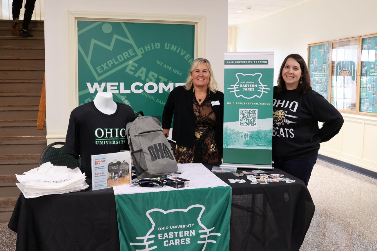 Jennifer Kellner-Muscar and another OHIO representative stand behind an OHIO University Eastern welcome table