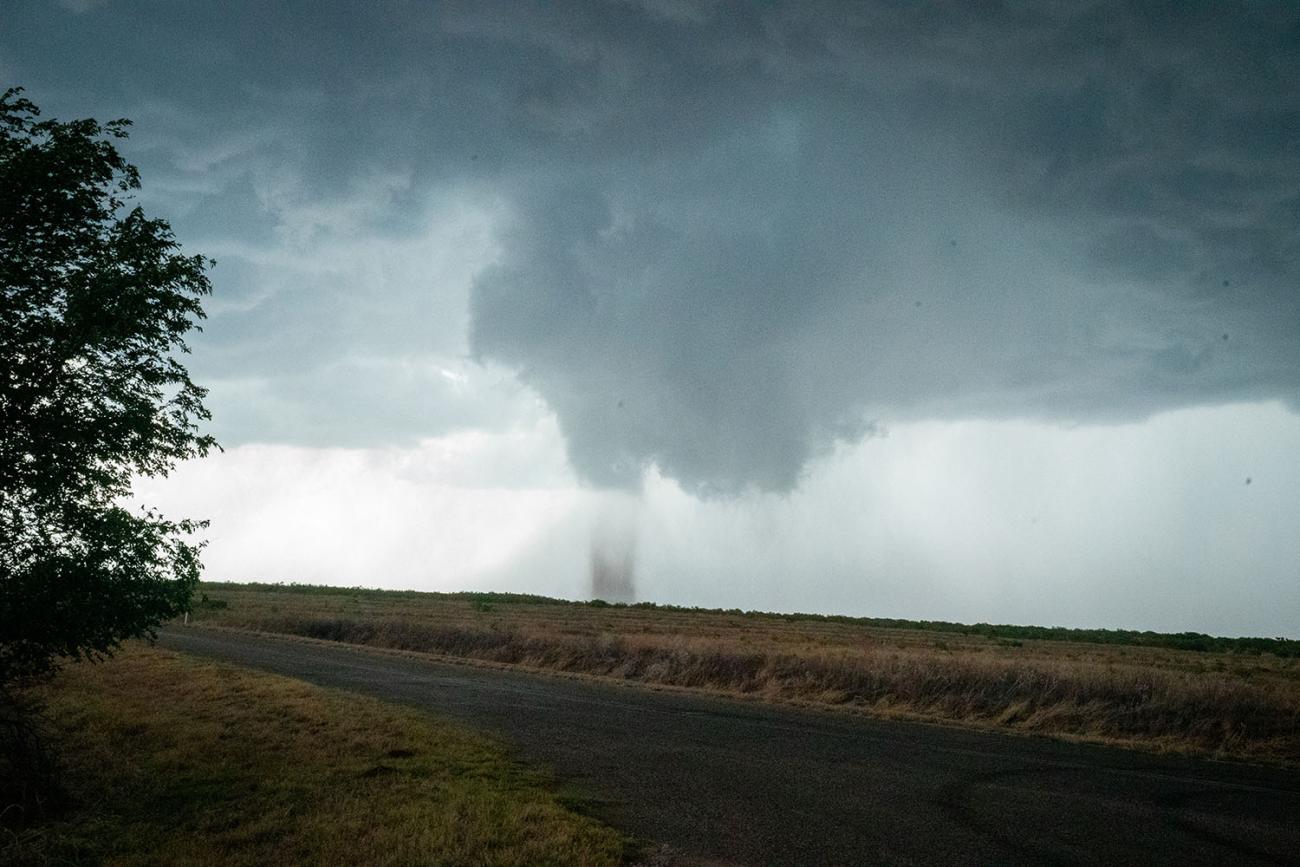 A tornado is shown over the ground