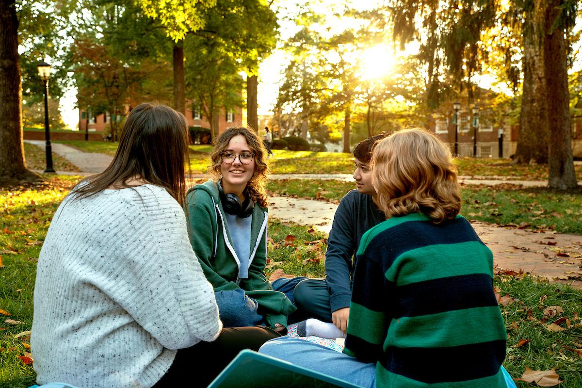 OHIO students sit together outside on the College Green