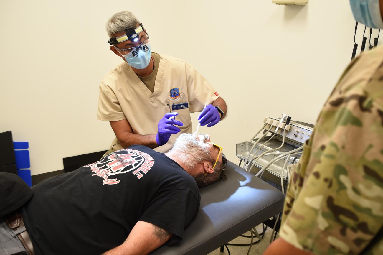 A dentist with the National Guard examines a patient