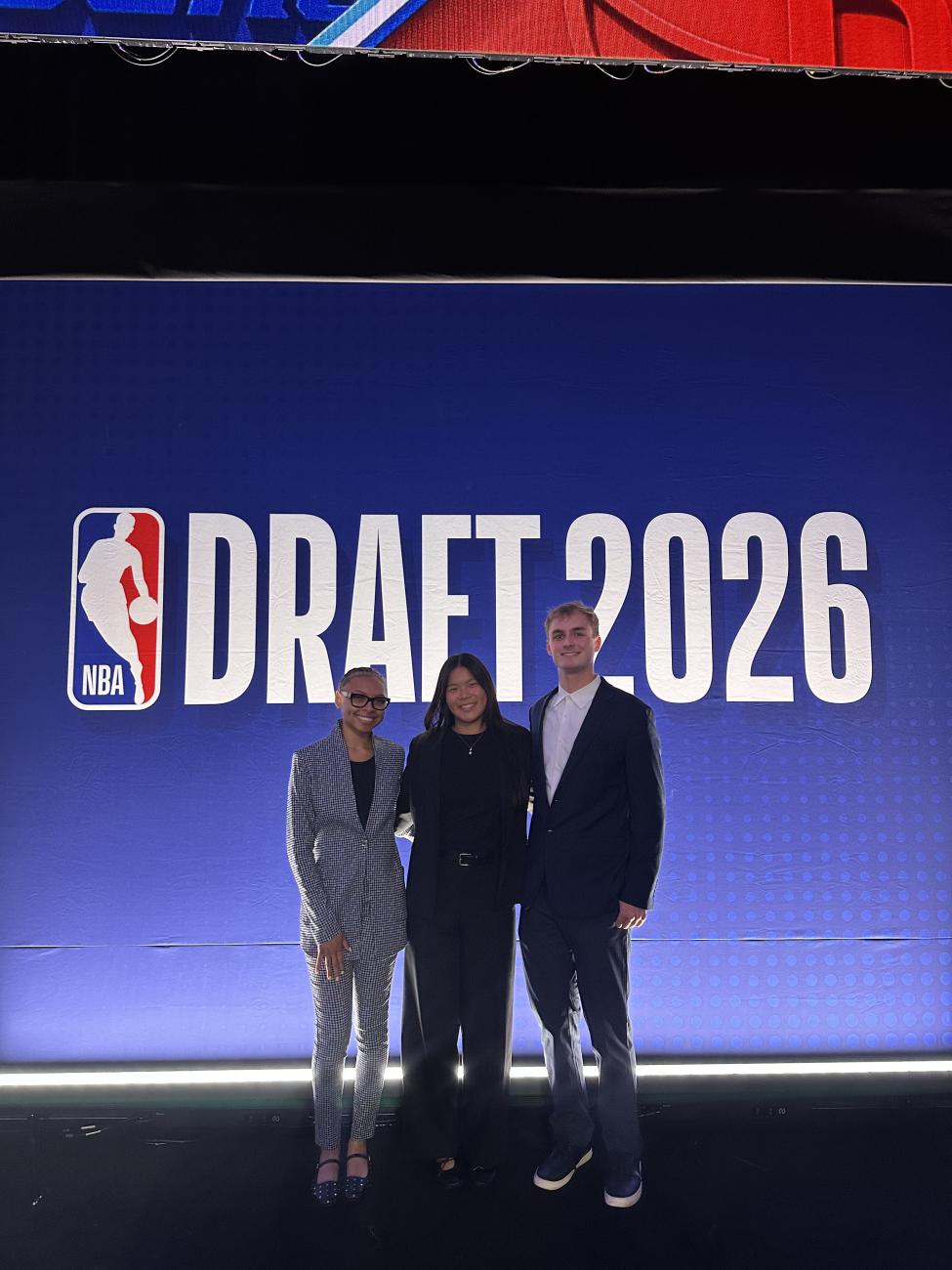 Quinn Elfers and collegues standing in front of a sign for the NBA Draft 2026.