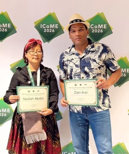 two people stand side-by-side holding certificates and posing for the picture