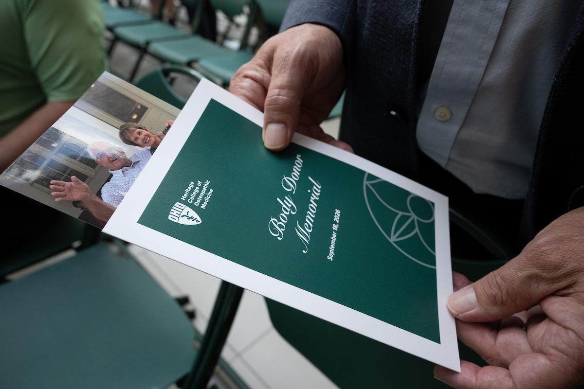 A family member holds a photograph and program for the Body Donor Memorial Service