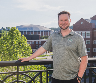Headshot of man standing in front of buildings