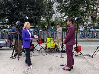 two female reporters stand on the street facing each other; on the right is OHIO alumna Jericka Duncan