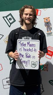 OHIO COB student Tyler Marco holding a sign saying he is heading to the Reds Organization for his summer internship.
